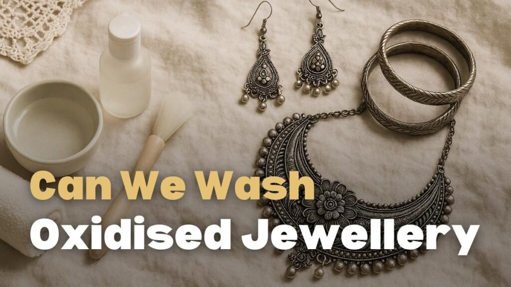 can we wash oxidised jewellery, A soft, crinkled off-white linen background with oxidized silver jewelry arranged on the right, including a floral statement necklace, dangling earrings, and chunky bangles. On the left, gentle cleaning tools are displayed: a ceramic bowl of clear water, a subtle bottle, a rolled microfiber cloth, and a small, soft-bristled jewelry cleaning brush with a wooden handle. The scene is lit with warm natural light, evoking a cozy, vintage boho aesthetic
