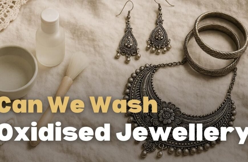can we wash oxidised jewellery, A soft, crinkled off-white linen background with oxidized silver jewelry arranged on the right, including a floral statement necklace, dangling earrings, and chunky bangles. On the left, gentle cleaning tools are displayed: a ceramic bowl of clear water, a subtle bottle, a rolled microfiber cloth, and a small, soft-bristled jewelry cleaning brush with a wooden handle. The scene is lit with warm natural light, evoking a cozy, vintage boho aesthetic
