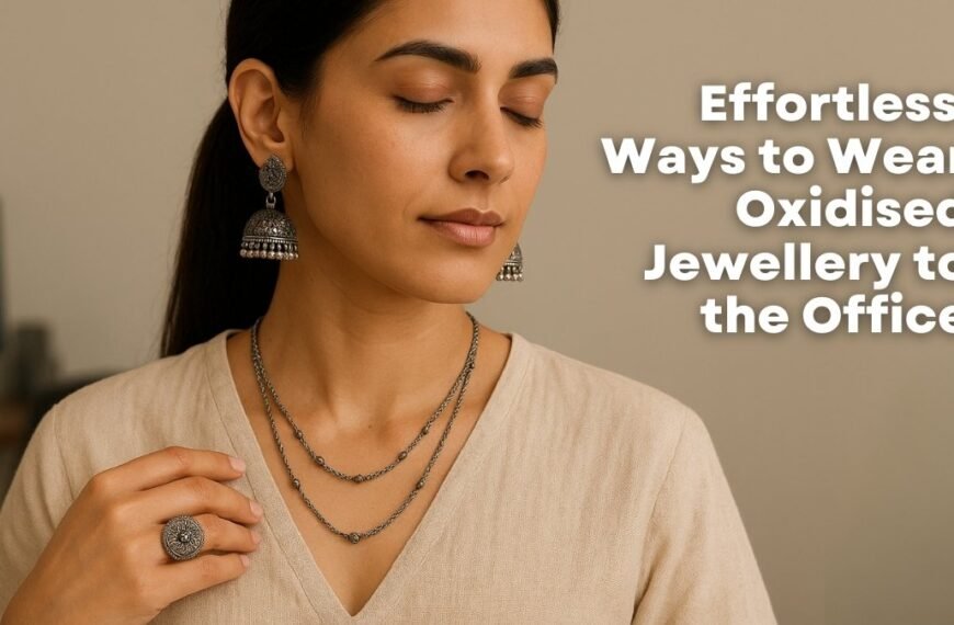 woman wearing oxidised silver jhumka earrings, layered necklace, and a statement ring, styled with an off-white khadi V-neck blouse in a modern boho office setting. 5 Effortless Ways to Wear Oxidised Jewellery to the Office