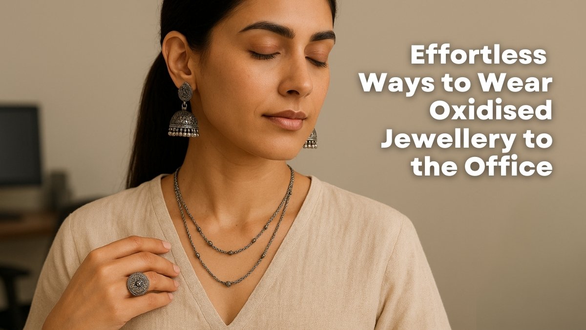 woman wearing oxidised silver jhumka earrings, layered necklace, and a statement ring, styled with an off-white khadi V-neck blouse in a modern boho office setting. 5 Effortless Ways to Wear Oxidised Jewellery to the Office