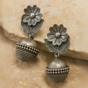 Flatlay Detailed view of floral motif and beadwork on oxidised jhumki.