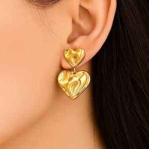 Gold Double Heart Anti Tarnish Earrings worn on model ear – 18K gold plated hammered drop design, waterproof stainless steel, lightweight, hypoallergenic, with push plug closure – Avvni The Store