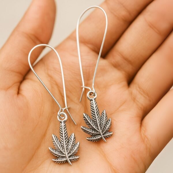 Avvni Filigree Leaf Motif Oxidised Earrings front view on palm