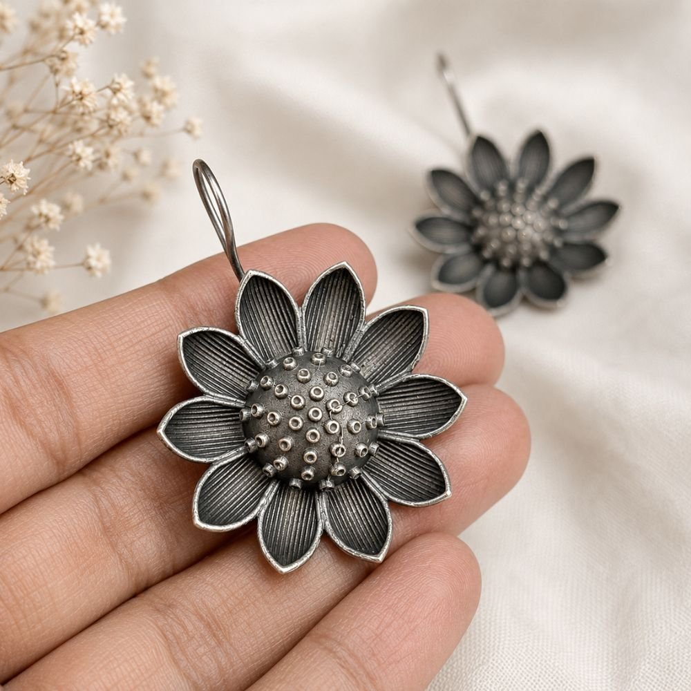 Avvni Oxidised Silver Sunflower Earrings | Avvni The Store Handheld view of detailed Oxidised Silver Sunflower Earrings