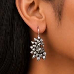 Avvni Oxidised Silver Peacock Drop Earrings with intricate peacock design worn on model ear