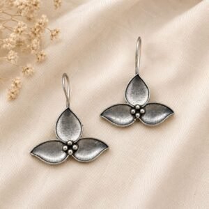 Close-up of three-petal floral design on oxidised silver earrings